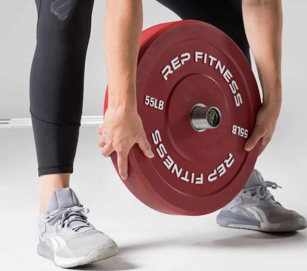 Bumper Plate being loaded onto an Olympic Barbell