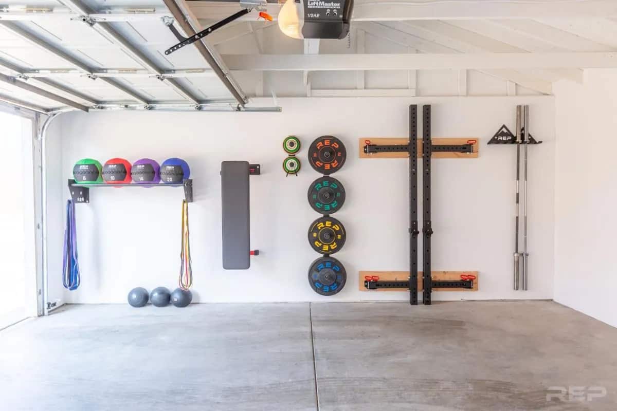 rep fitness equipment stored neatly in a garage gym
