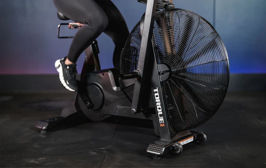 Torque Fitness Stealth Air Bike with an athlete