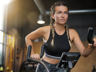 Young woman working out with an air bike.