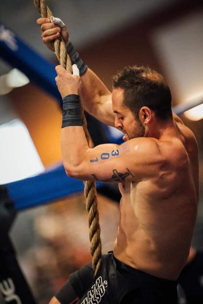 Rich Froning using Rogue Wrist Bands to keep his grip dry during a CrossFit competition.